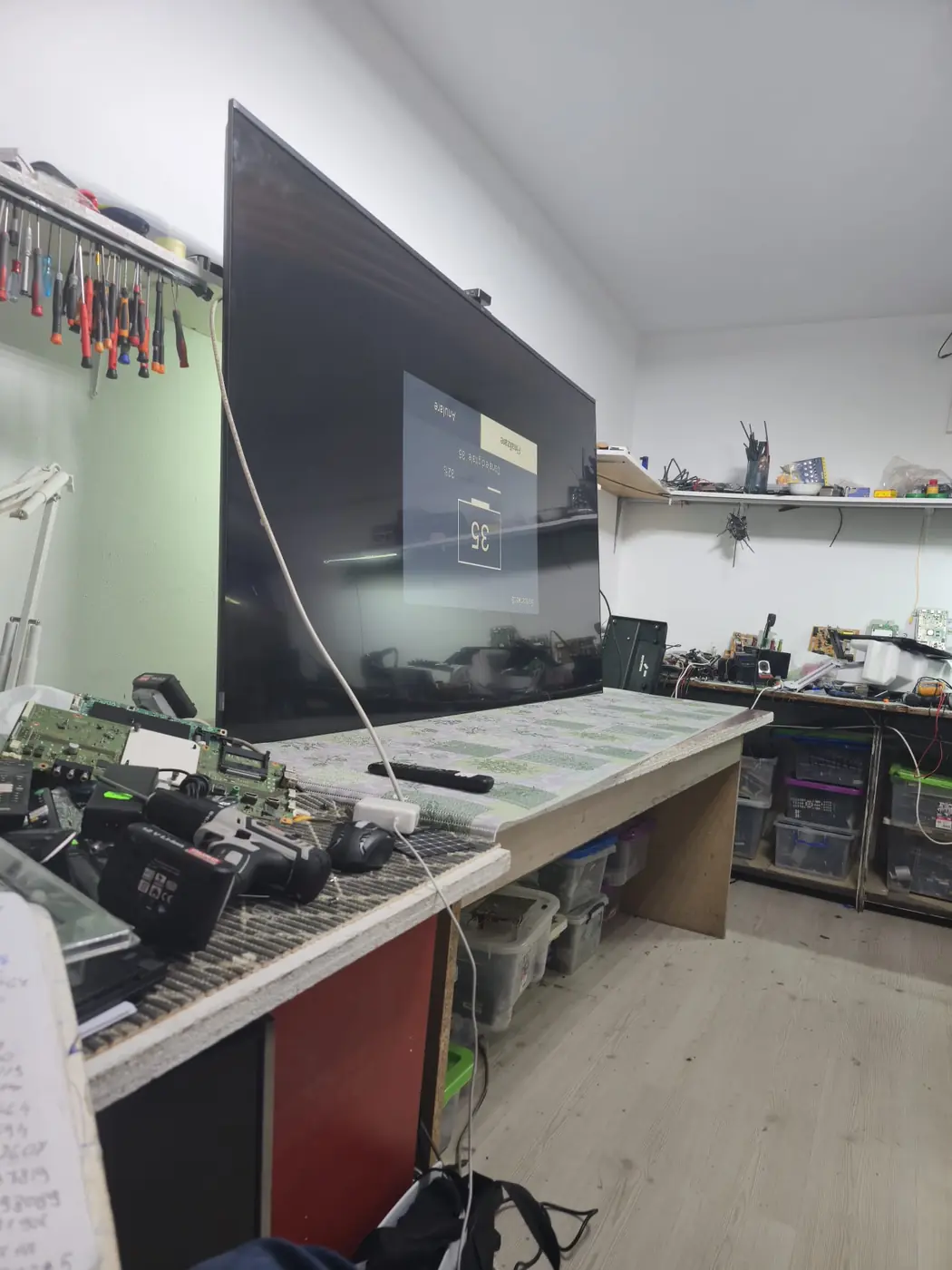 Televizor TCL 85C755 de 85 de inch pe bancul de lucru din atelierul din Militari, în timpul testului după reparația plăcii de bază